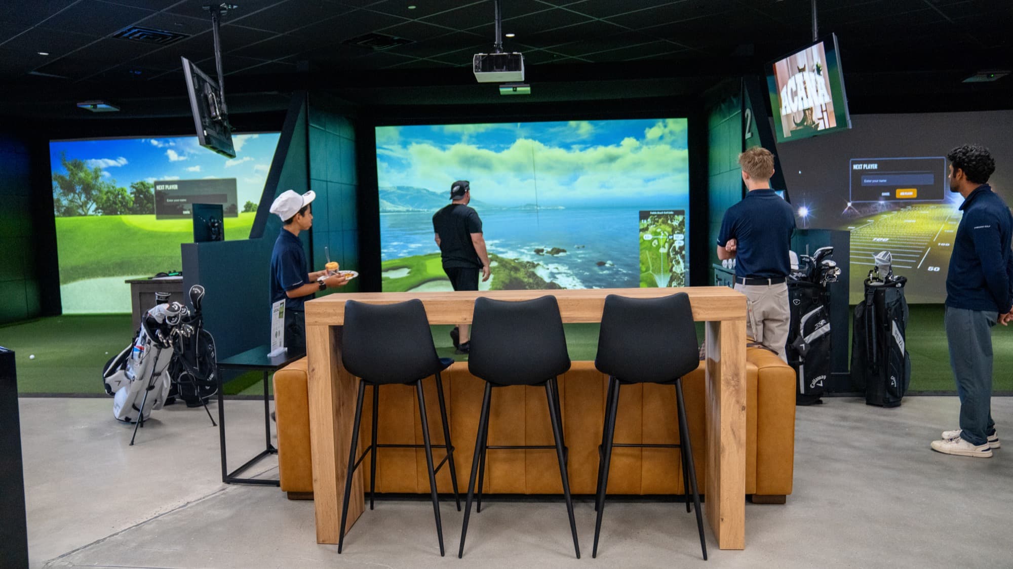 A group of guys enjoying a simulator bay at Unbound Golf